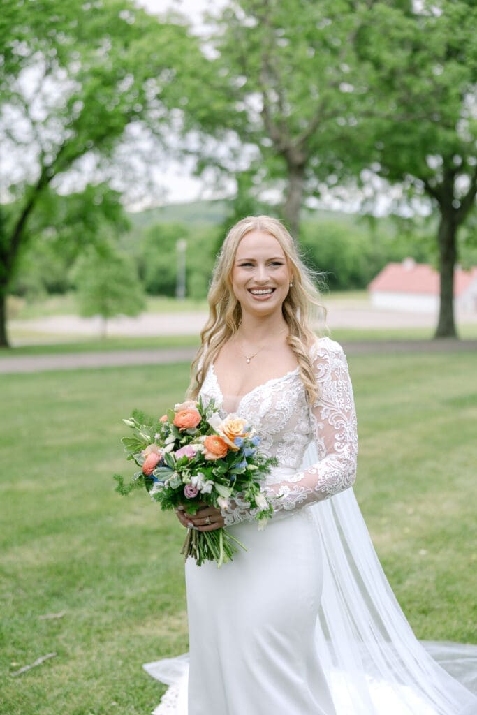 bride poses for photos at her wedding in front of ravenswood mansion in Franklin, TN with her gorgeous bouquet from larson's floral co