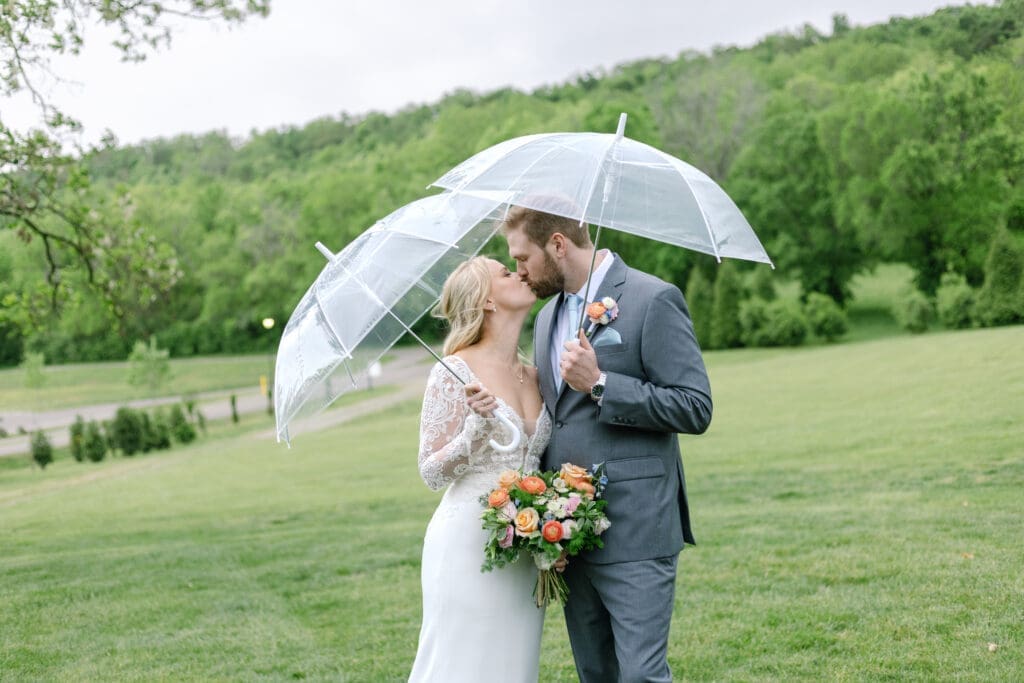 bride and groom share a moment under their umbrella during a spring shower on their wedding day a romantic spring wedding at Ravenswood Mansion in Franklin, TN with gorgeous florals from Larson's Floral Co.