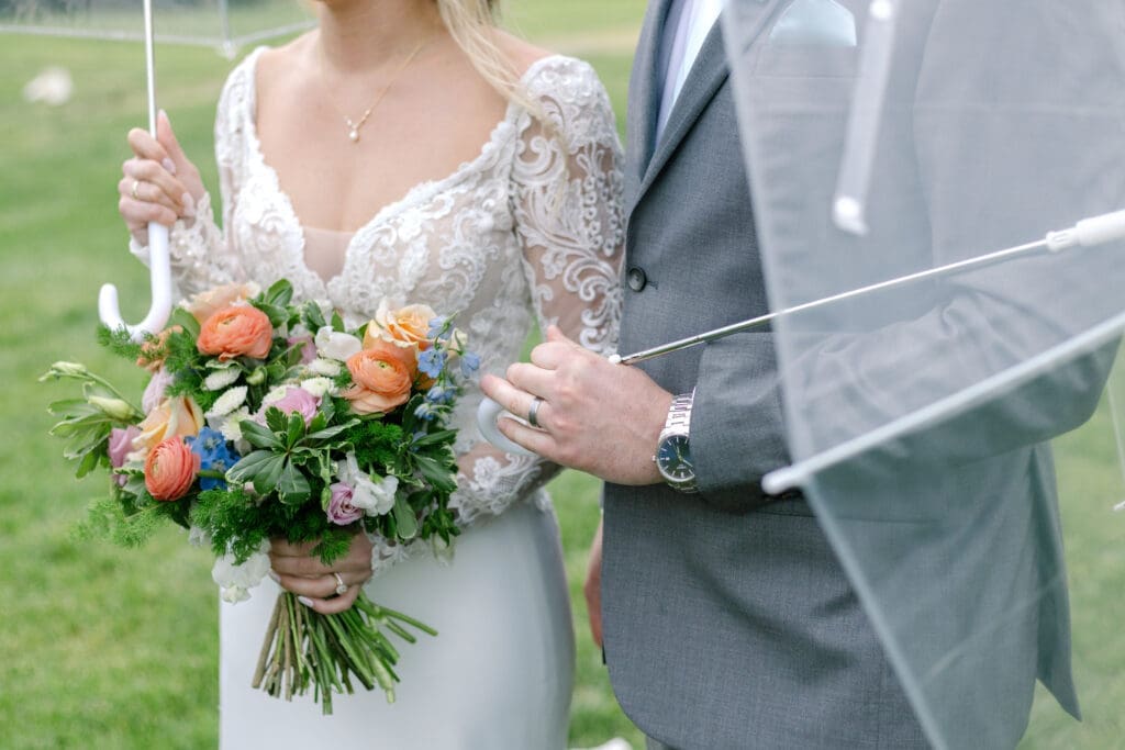 bride and groom share a moment under their umbrella during a spring shower on their wedding day a romantic spring wedding at Ravenswood Mansion in Franklin, TN with gorgeous florals from Larson's Floral Co.