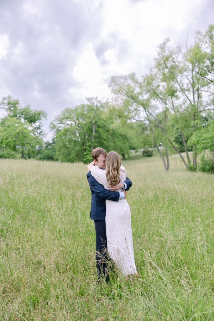 Newly engaged couple hugging one another outdoors during light and airy Nashville engagement session