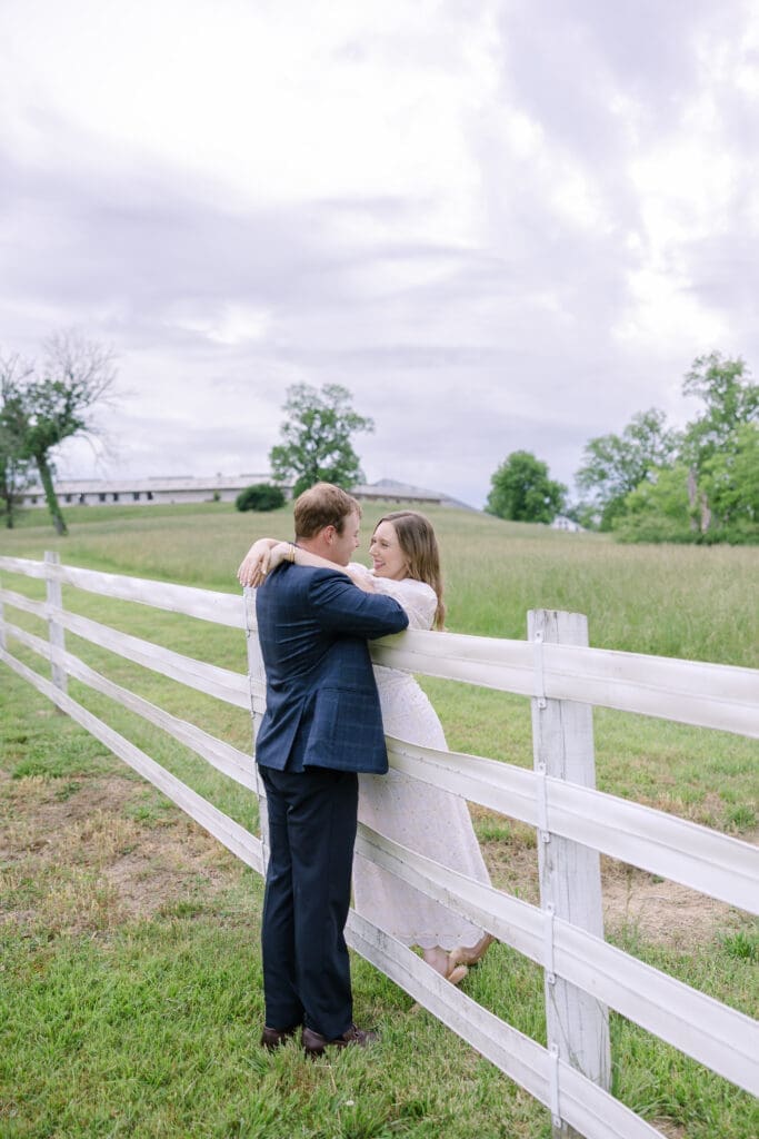 Couple leaned up on a fence sharing a hug together at their destination Nashville engagement session