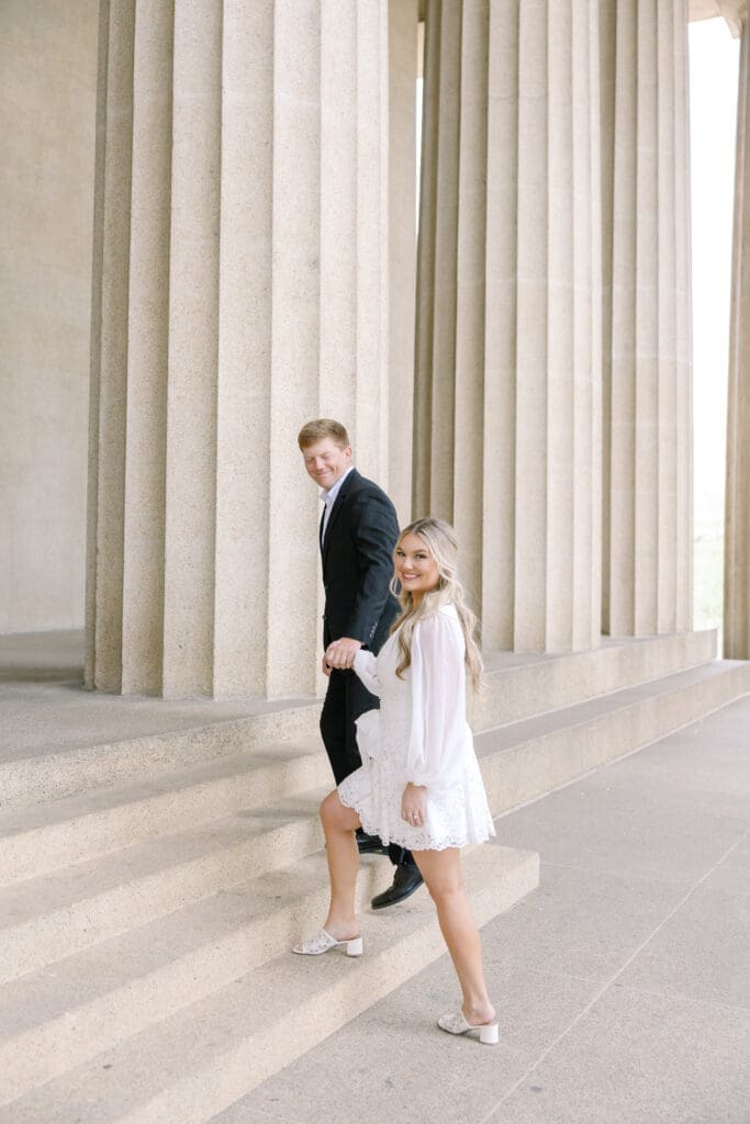 Katie and Matt standing in front of the Parthenon columns during their Nashville engagement session in the spring