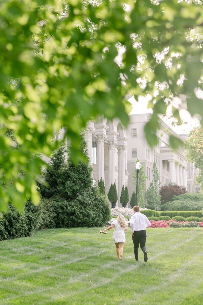 Wide shot of couple running through Belmonts campus in Nashville, TN