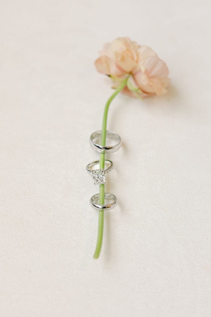 wedding detail shot of ranunculus floral stem and gorgeous custom wedding bands