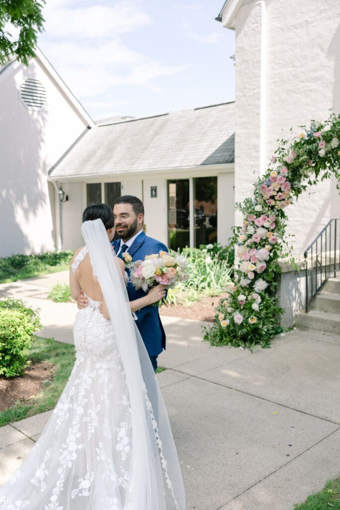 bride and groom pose in front of beautiful floral arch by Tulia Grace Florals in franklin, tn