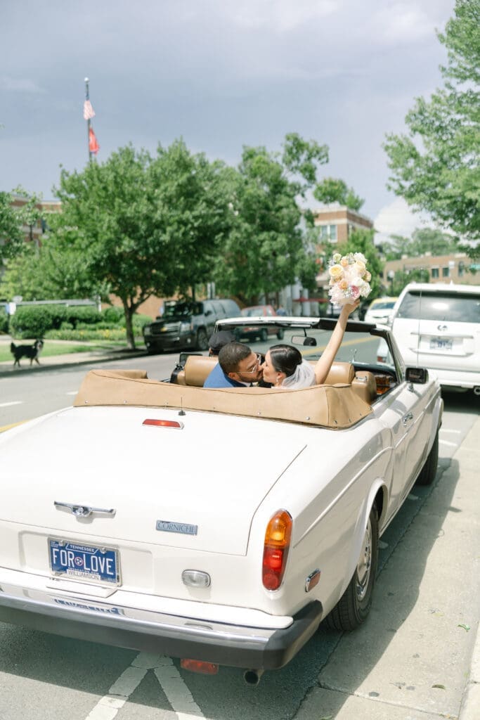 bride and groom drive away in classic rolls royce in their intimate franklin, tn wedding at cj's off the square